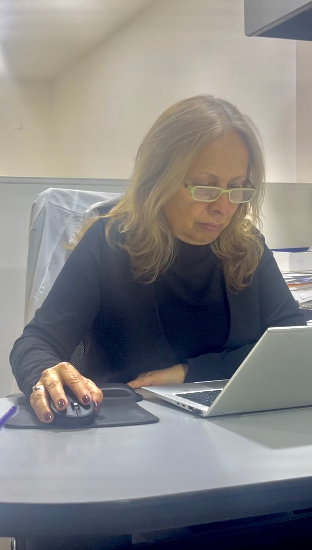 Dra. Ana Belén España trabajando en el escritorio de Óptica Apolo